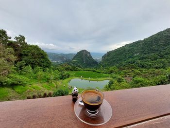 View of coffee and mountains against sky
