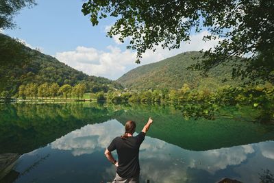 Reflection of person photographing in lake