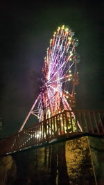 Low angle view of illuminated fireworks against sky at night