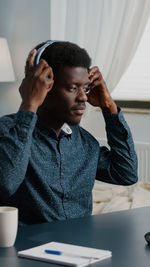 Man wearing headphones while sitting at home