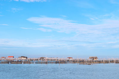 Buildings by sea against sky