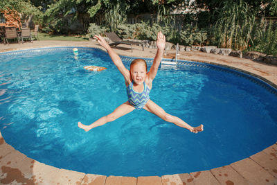 Girl jumping in swimming pool