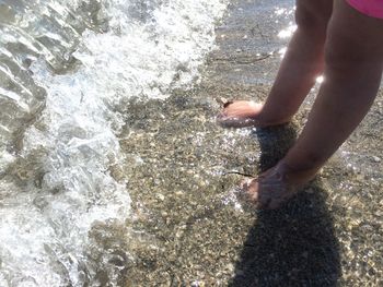 Low section of people standing on beach