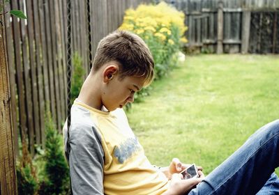 Side view of boy using phone