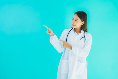 Young woman standing against blue background