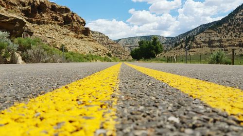 Surface level of road with double yellow lines amidst mountains