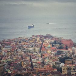 High angle view of townscape by sea against sky