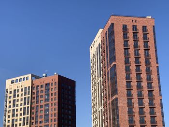 Low angle view of modern buildings against clear blue sky