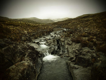 Scenic view of river amidst mountains against sky