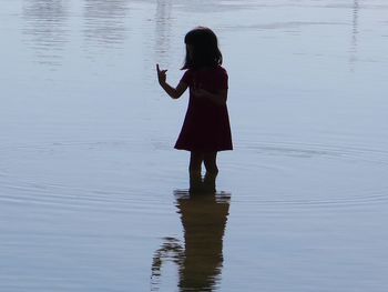 Rear view of girl standing in lake