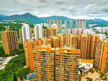 View of cityscape against cloudy sky