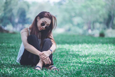 Portrait of young woman sitting on field