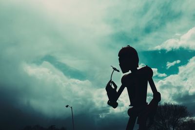 Low angle view of silhouette man standing against sky