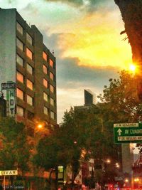 Illuminated buildings against sky during sunset