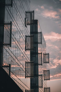 Low angle view of modern building against sky during sunset