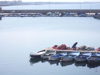 Boats moored at harbor against sky