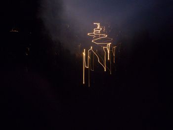 Low angle view of illuminated light against sky at night