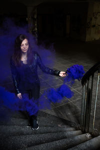 Portrait of woman standing on purple at night
