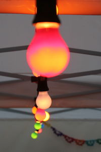 Close-up of illuminated light bulb against sky at sunset
