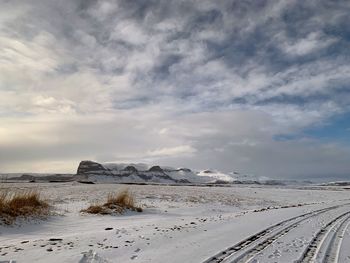 Scenic view of snow covered land against sky