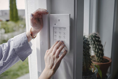 Woman entering alarm code into keypad