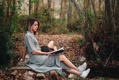 Young woman using mobile phone in forest