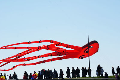 Group of people on runway against clear sky