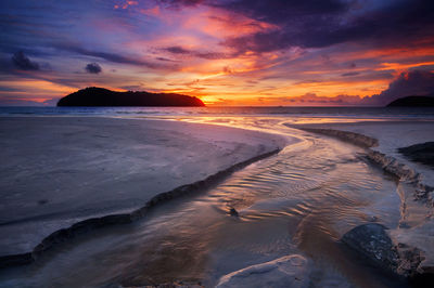 Scenic view of beach against sky during sunset