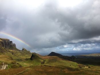 Scenic view of rainbow over landscape against sky