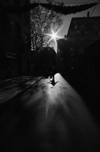 Man in illuminated city against sky