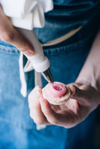 Midsection of woman icing cookie