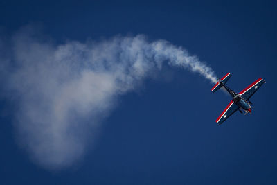 Low angle view of airplane against sky during airshow