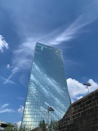 Low angle view of modern building against cloudy sky