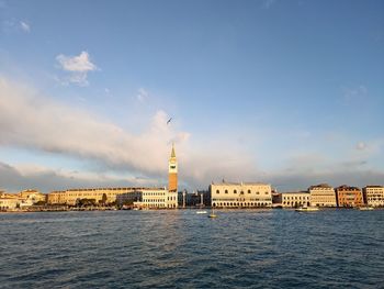 Buildings by sea against sky in city