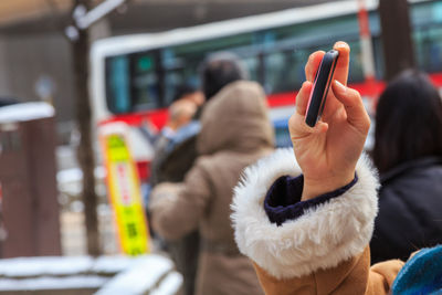 Close-up of woman hand photographing with mobile phone in city