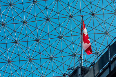Low angle view of flag on building against sky