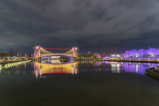 illuminated, water, night, architecture, built structure, connection, bridge - man made structure, waterfront, sky, reflection, transportation, river, bridge, nautical vessel, travel destinations, engineering, travel, suspension bridge, famous place, cloud - sky