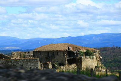 Old historic building by mountains against sky