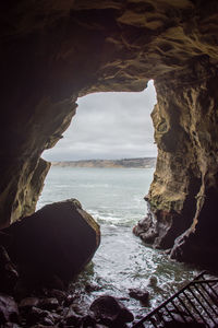 Scenic view of sea seen through cave