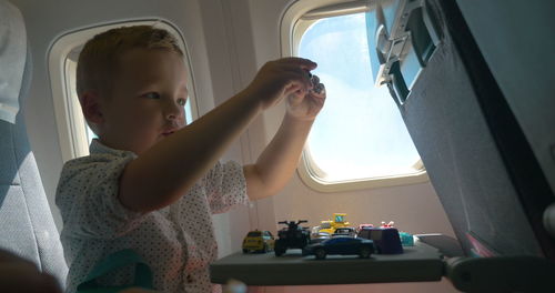 Close-up of boy playing while sitting in air plane