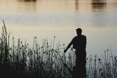 Silhouette of woman standing in lake