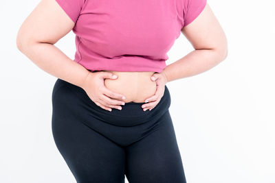 Midsection of woman touching face against white background