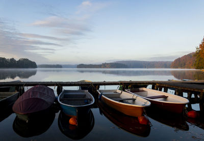 Boats moored in lake against sky