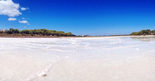 Scenic view of beach against blue sky