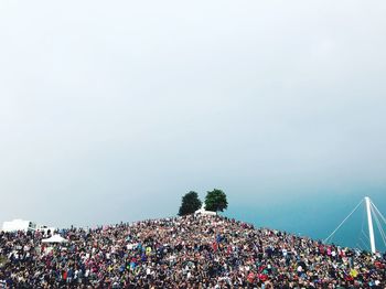 Group of people at music concert against sky