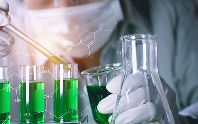 Digital composite image of man examining chemical in laboratory