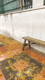 Empty bench by footpath in park during autumn