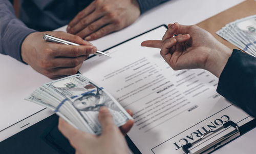 Midsection of man holding paper with text