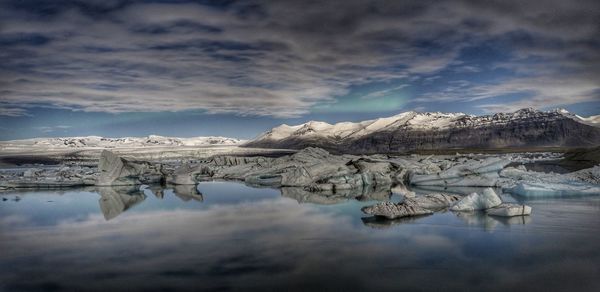 Panoramic view of frozen lake against sky