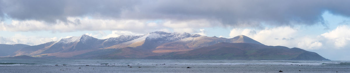 Panoramic view of sea and mountains against sky